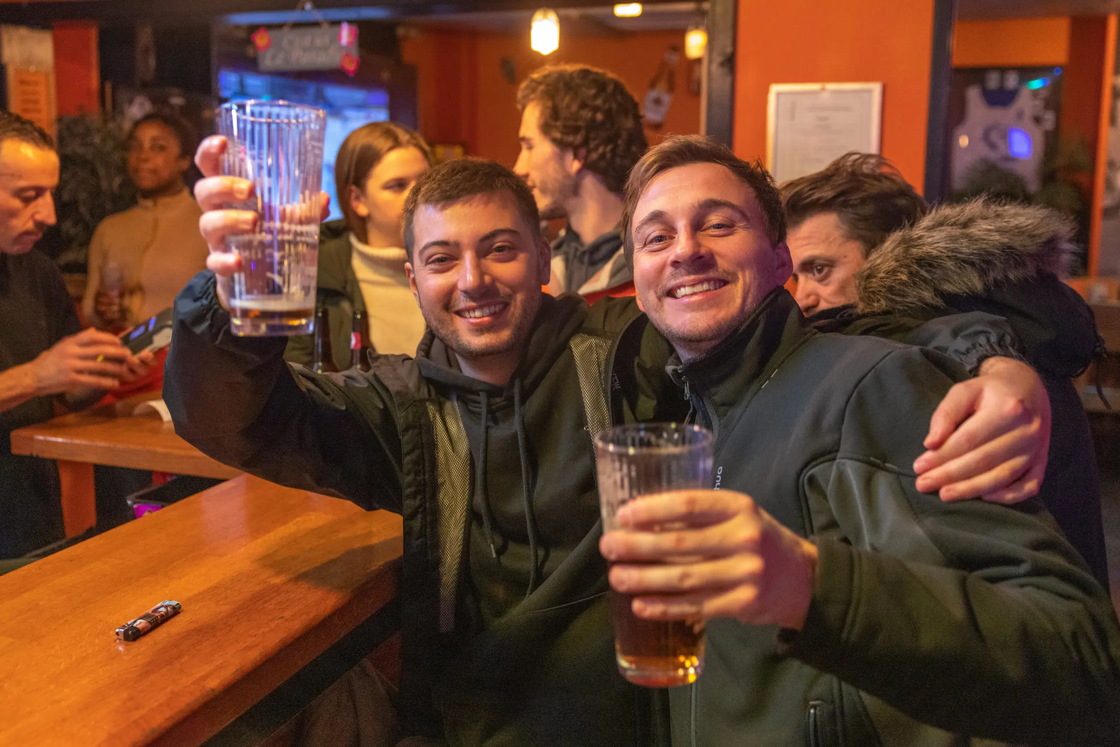 Deux amis trinquent avec une pinte au pub Les Gosses du Québec