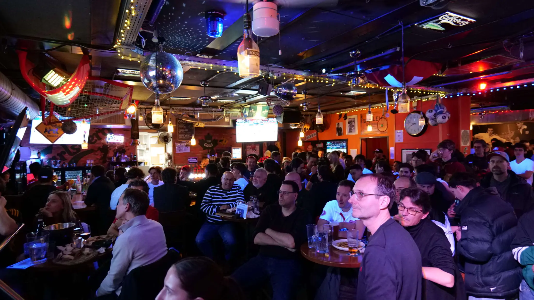 Salle comble devant un match de hockey sur grand écran